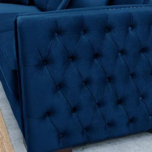 Navy blue velvet sofa with tufted armrest and matching scatter cushions