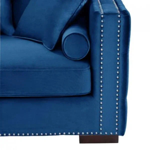 Blue velvet sofa corner with silver stud detail and matching cushions