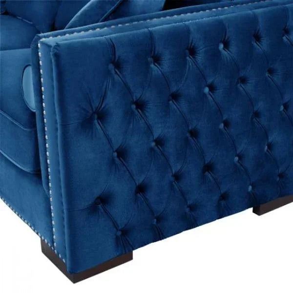 Blue velvet sofa arm with tufted upholstery and decorative stud detailing