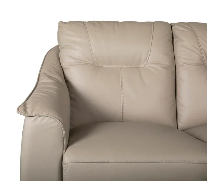 Beige leather sofa close-up showing padded armrest and stitched seat detail