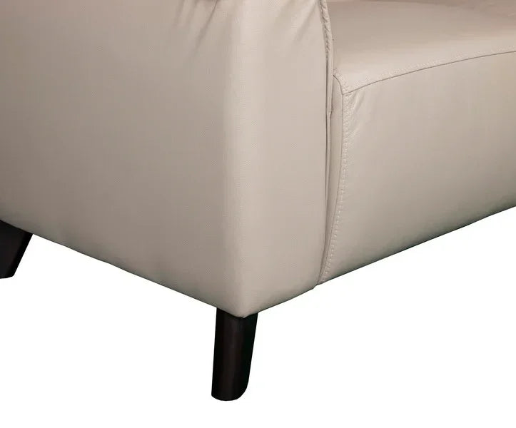 Close view of beige sofa arm with wooden legs and smooth leather upholstery