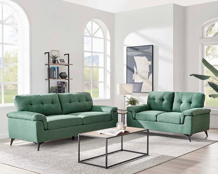 Green fabric sofa set with button-tufted cushions in a modern living room with large windows