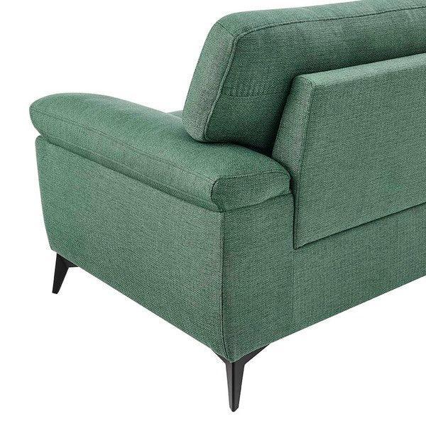 Green fabric sofa corner with black metal legs, showing armrest and backrest detail