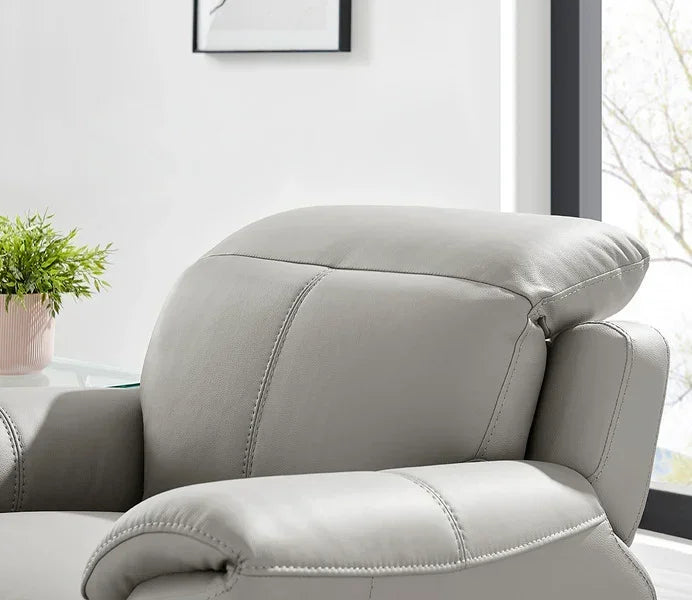Light grey leather sofa with adjustable headrest and armrest detail near window