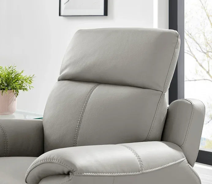 Light grey leather sofa with padded armrest and headrest in modern living room