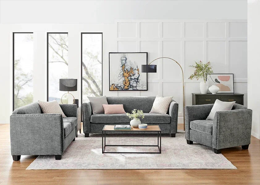 Grey fabric sofa set with pastel cushions, coffee table, and modern decor in bright living room