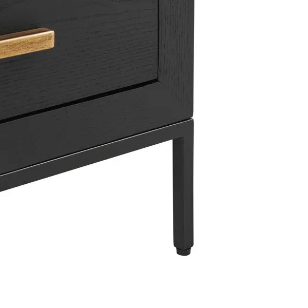 Black wooden bedside table leg and corner with gold drawer handle