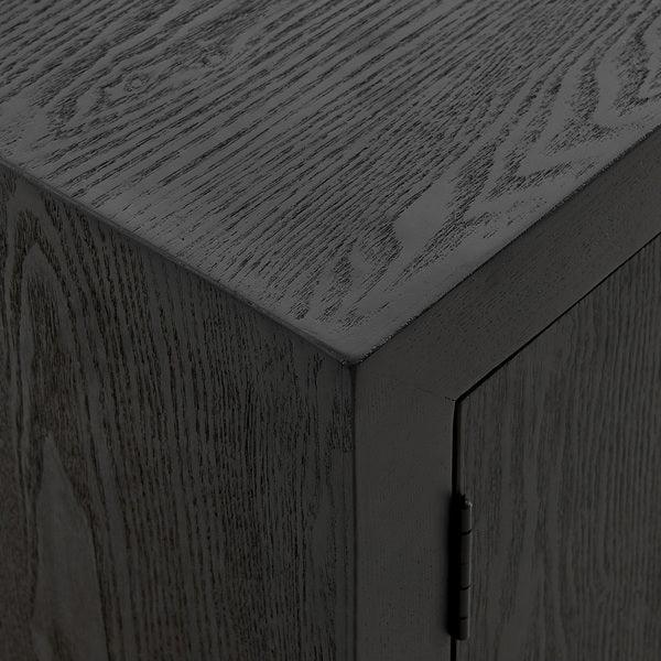 Black wood cabinet corner with visible grain and hinge detail