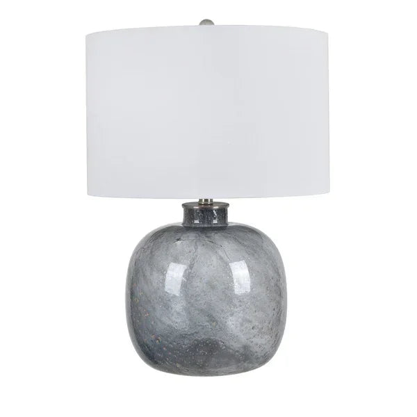 Grey ceramic table lamp with round base and white drum lampshade