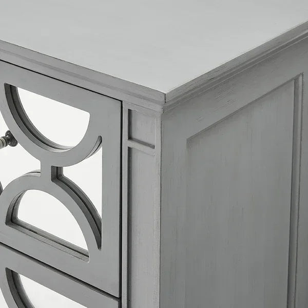 Grey wooden chest of drawers with geometric mirrored drawer fronts, corner view