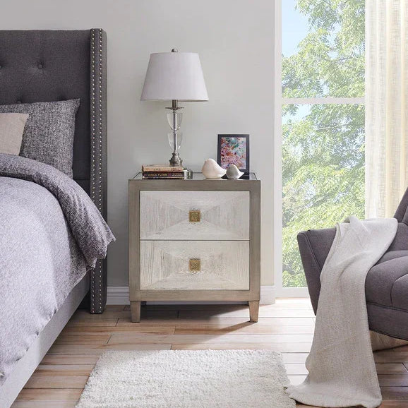 Modern wooden bedside table with two drawers beside upholstered bed in bright bedroom