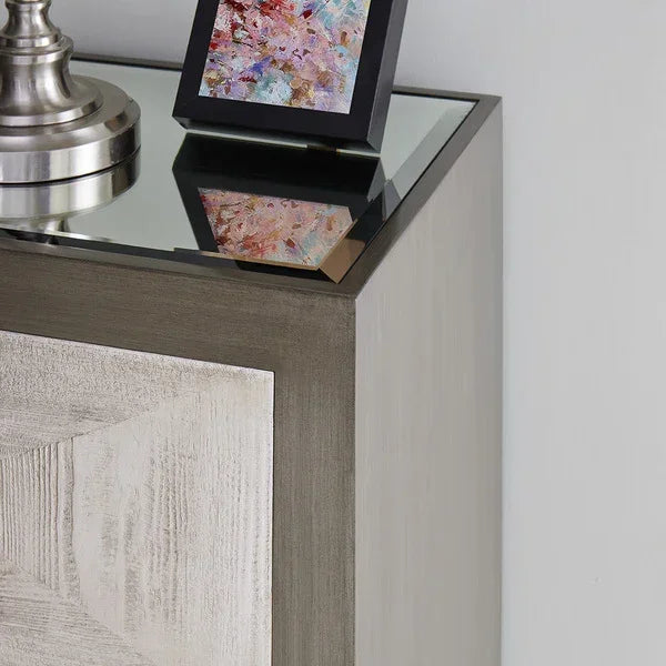 Modern wooden bedside table with glass top, silver lamp, and framed art decor