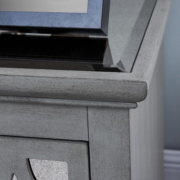 Grey wood bedside table with glass top and decorative drawer panel close-up