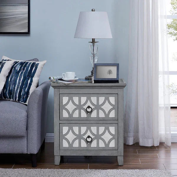 Grey wooden bedside table with two drawers, geometric pattern, lamp and decor accents