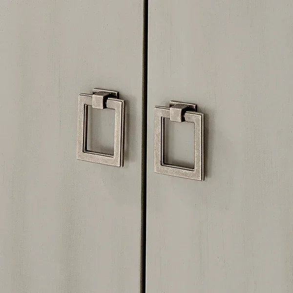 Close up of metal square cabinet handles on light wood cupboard doors