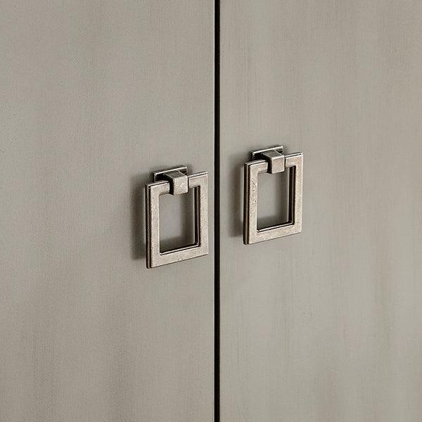 Square metal cabinet handles on grey wooden door front, close-up view