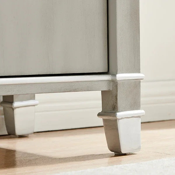 Light grey wooden furniture legs on hardwood floor, close-up view