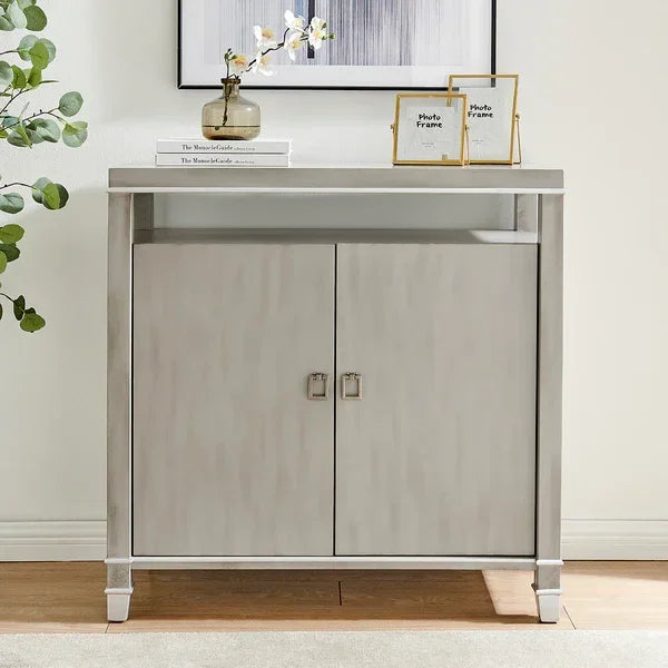 Light grey two door sideboard with metal handles and shelf, styled with vase and photo frames