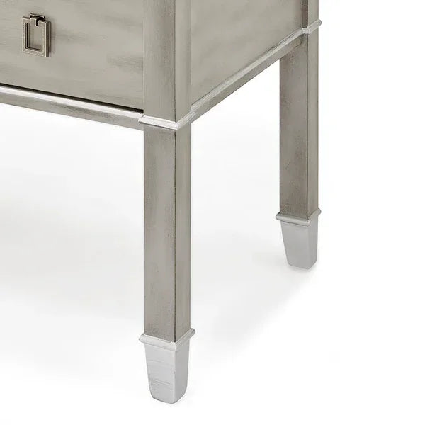Silver wooden bedside table corner showing tapered legs and lower drawer detail