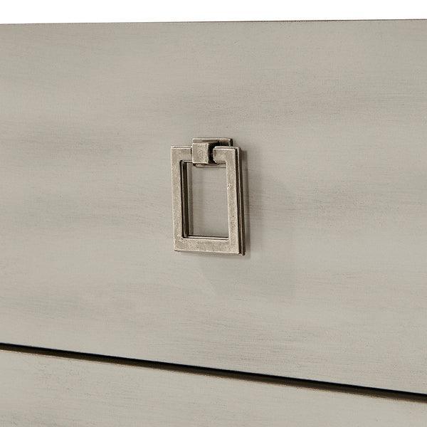 Closeup of metal drawer handle on light wood dresser