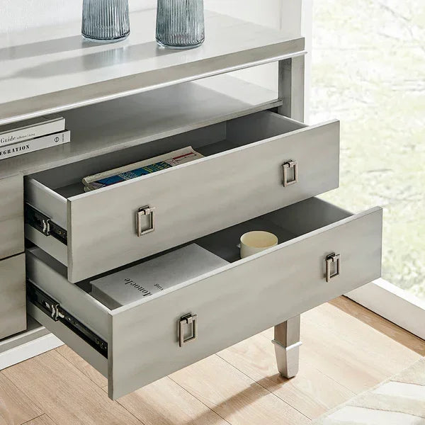 Light grey wooden console table with two open drawers, modern metal handles, and books inside