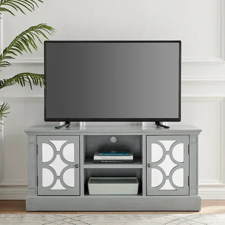 Grey TV unit with decorative cabinet doors, open shelves, and a flat screen television on top