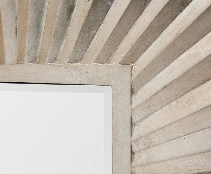 Close-up of wooden mirror frame with carved geometric pattern and light natural finish
