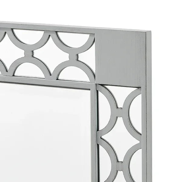 Silver wall mirror with geometric cut-out metal frame, close-up of corner detail