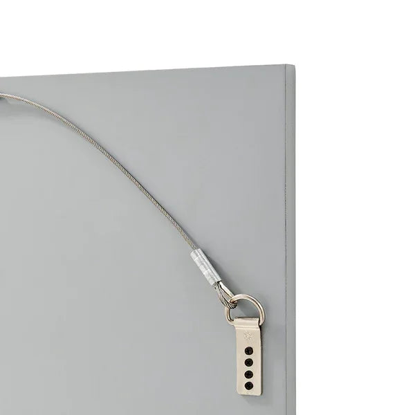 Closeup of grey furniture safety strap with metal cable and securing bracket