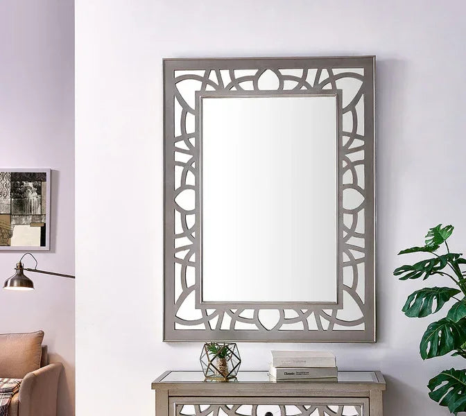 Rectangular wall mirror with geometric silver frame above console table in living room