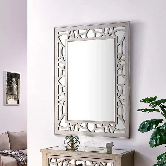 Rectangular wall mirror with geometric frame above wooden console in living room