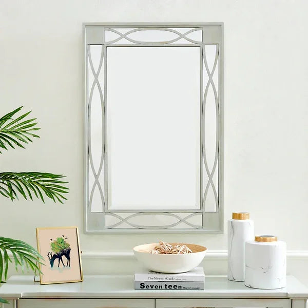 Rectangular decorative wall mirror with geometric silver frame above console table decor