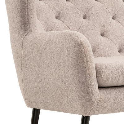 Beige boucle sofa with tufted backrest and black metal legs, close-up of armrest