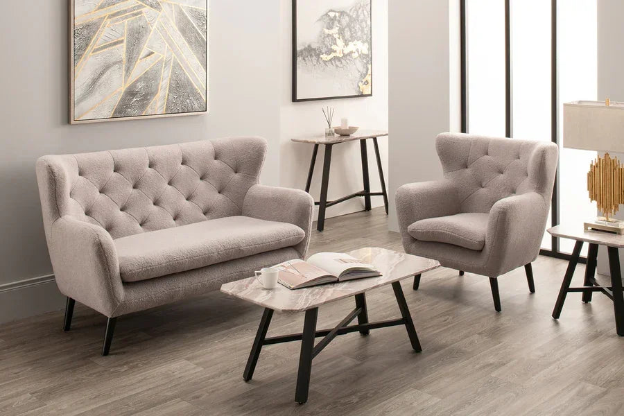 Light grey tufted fabric sofa and armchair set in a modern living room with marble coffee table