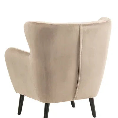 Beige velvet accent chair with black wooden legs, rear angle view