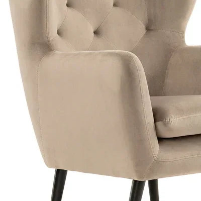 Beige armchair with tufted backrest and black angled legs, close side view