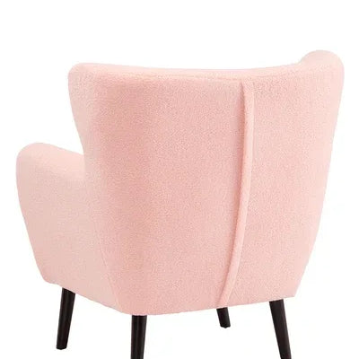 Blush pink accent chair with fabric upholstery and black wooden legs, rear view angle
