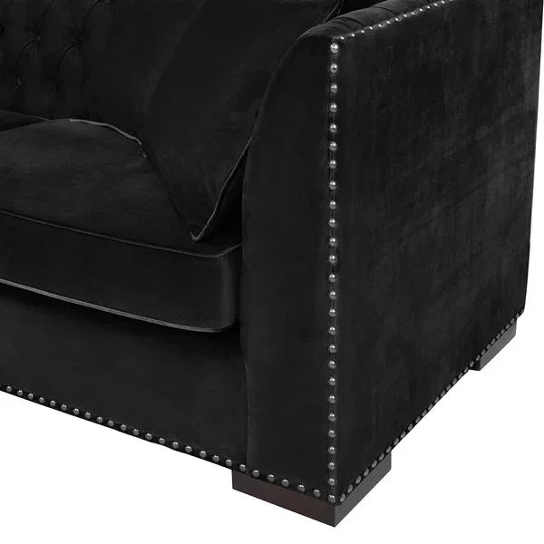 Black velvet sofa corner with silver studded trim and plush seat cushion