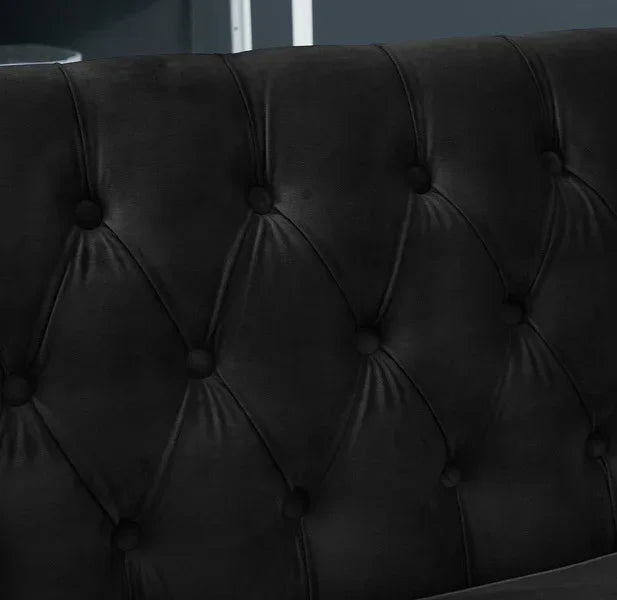 Black velvet sofa backrest with deep button tufting, close-up upholstery detail