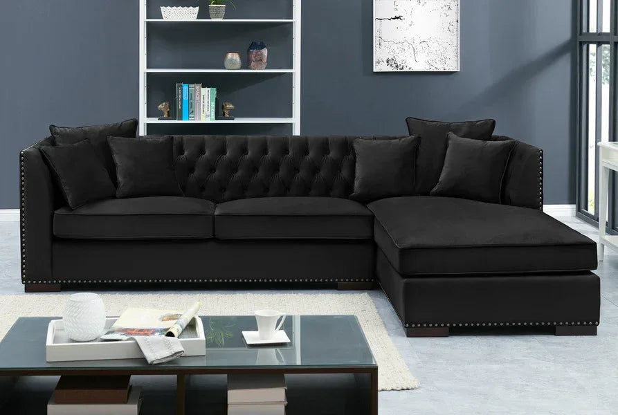 Black corner sofa with studded trim and tufted backrest in modern living room