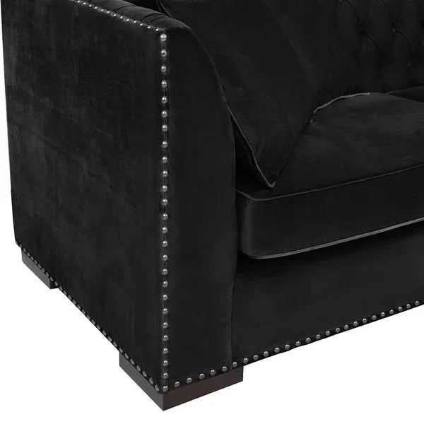 Black velvet sofa with silver studded trim and tufted cushion detail, left arm view