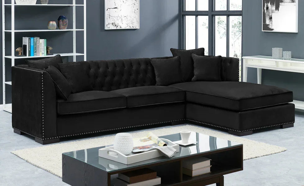 Black velvet corner sofa with studded trim and tufted back in modern living room