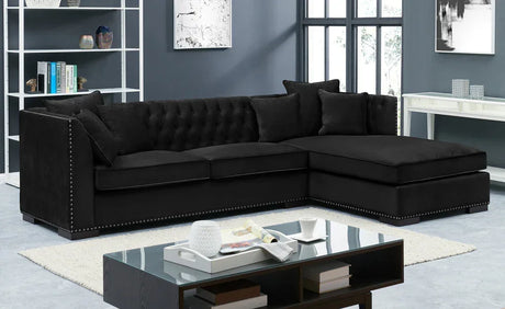 Black velvet corner sofa with studded trim and tufted back in modern living room
