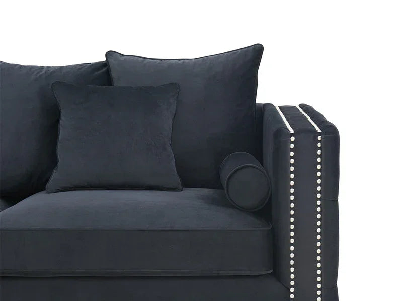 Dark velvet sofa corner with silver stud detailing and multiple scatter cushions