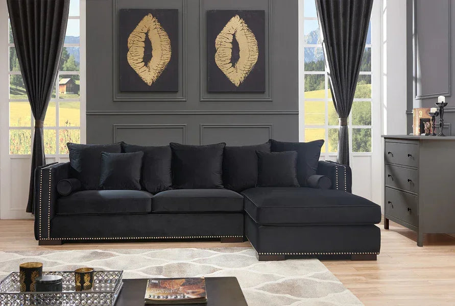 Black corner sofa with studded trim and scatter cushions in modern living room setting