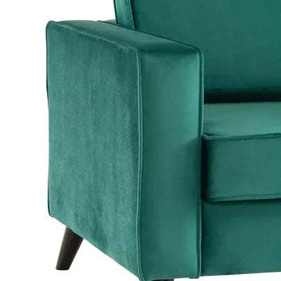 Green velvet sofa arm detail with black wooden legs, modern furniture close-up