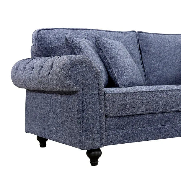Blue fabric sofa with tufted armrest and two matching scatter cushions