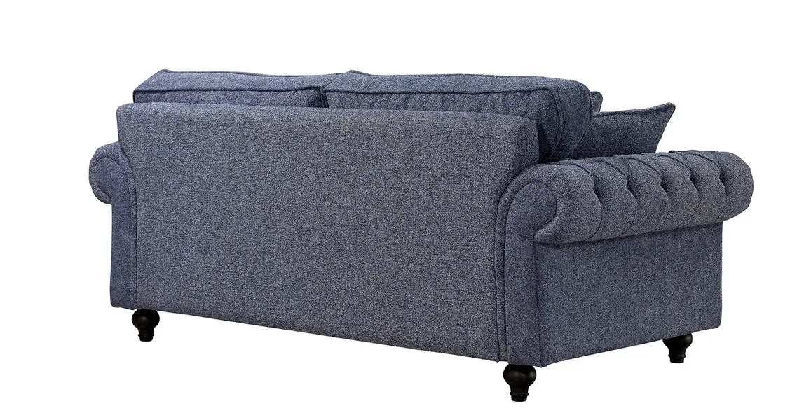 Back view of blue fabric sofa with tufted arms and wooden legs