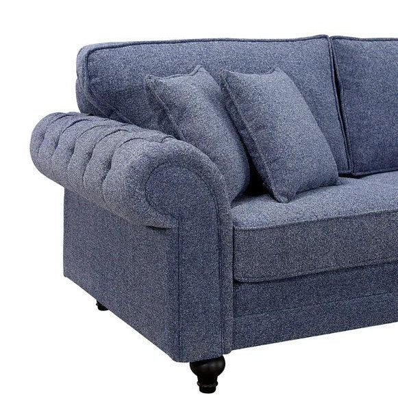 Blue fabric sofa with tufted armrest and matching scatter cushions, left side view