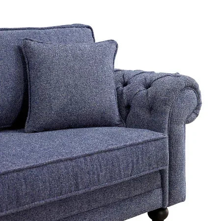Blue fabric sofa with cushion and tufted armrest, close side view